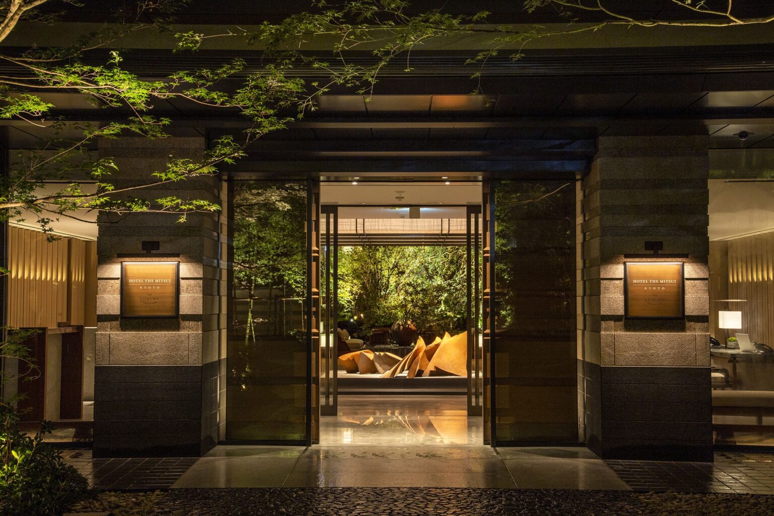 Stone-framed entrance to HOTEL THE MITSUI KYOTO at night