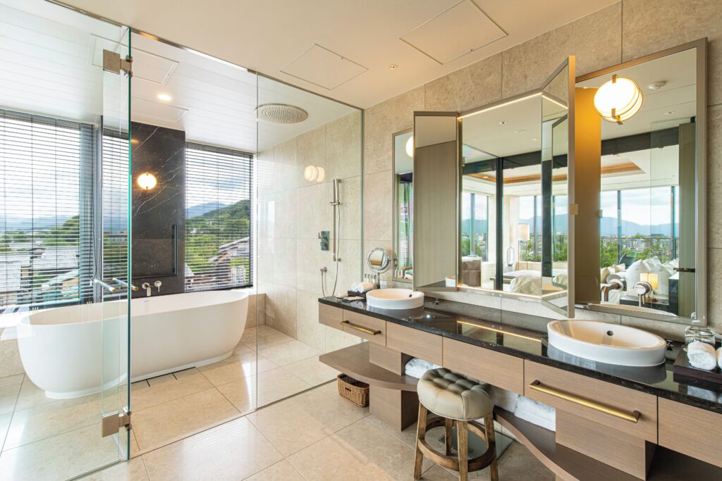 Guest bathroom with a freestanding tub, double basins and hillside view at The Hotel Seiryu Kyoto Kiyomizu