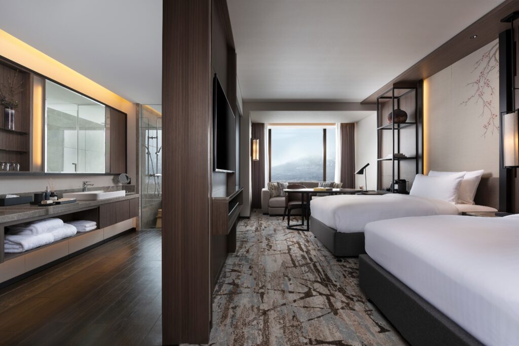 A twin guest room with an open vanity and mountain view at Higashiyama Niseko Village