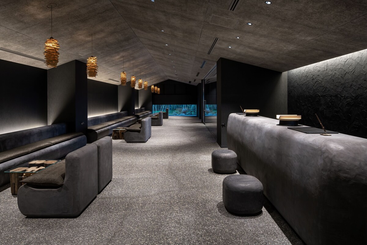 Dark reception lounge with woven pendant lights at Hoshino Resorts KAI Yufuin