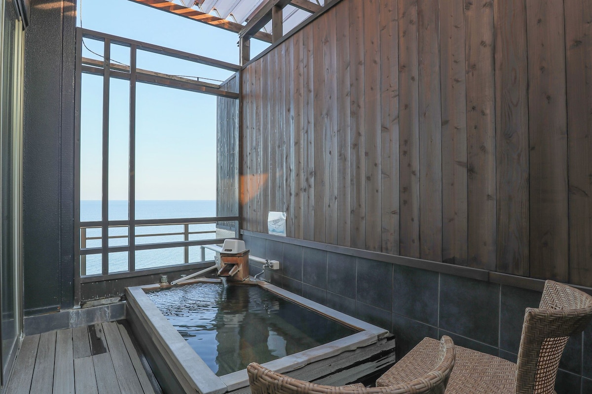 Sea-facing guest-room onsen bath at AMANE RESORT SEIKAI