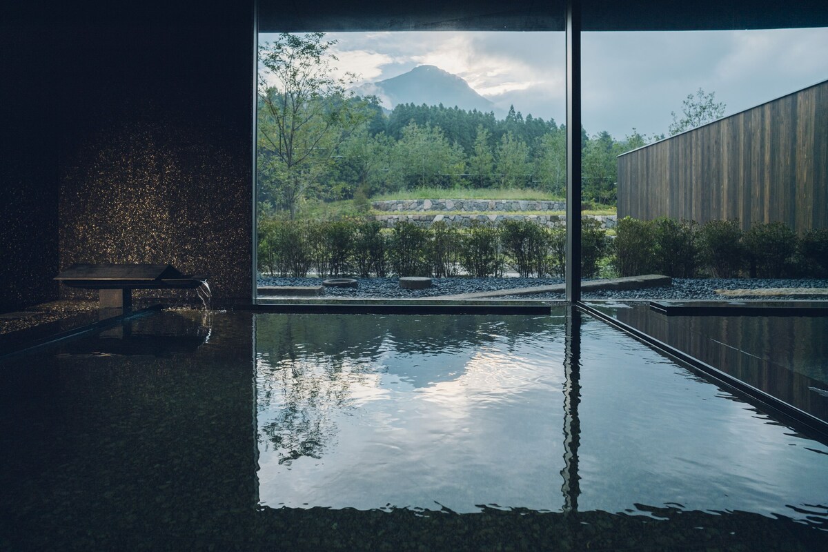Public hot-spring bath at Hoshino Resorts KAI Yufuin facing Mount Yufu