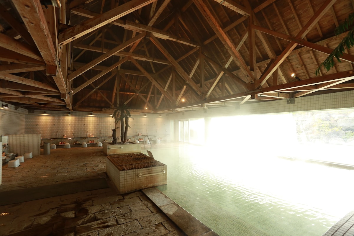 Indoor bath beneath a timber roof at Hotel Shiragiku