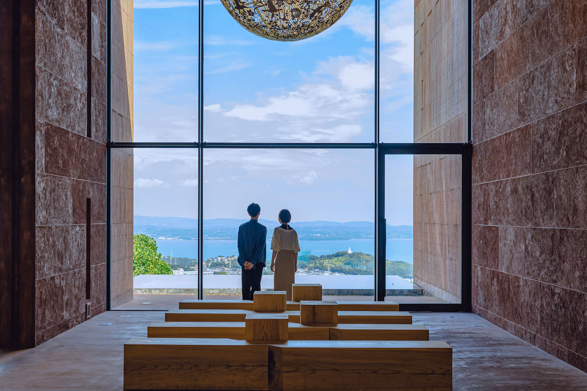 Interior seating framing the view across Beppu toward the bay at GALLERIA MIDOBARU