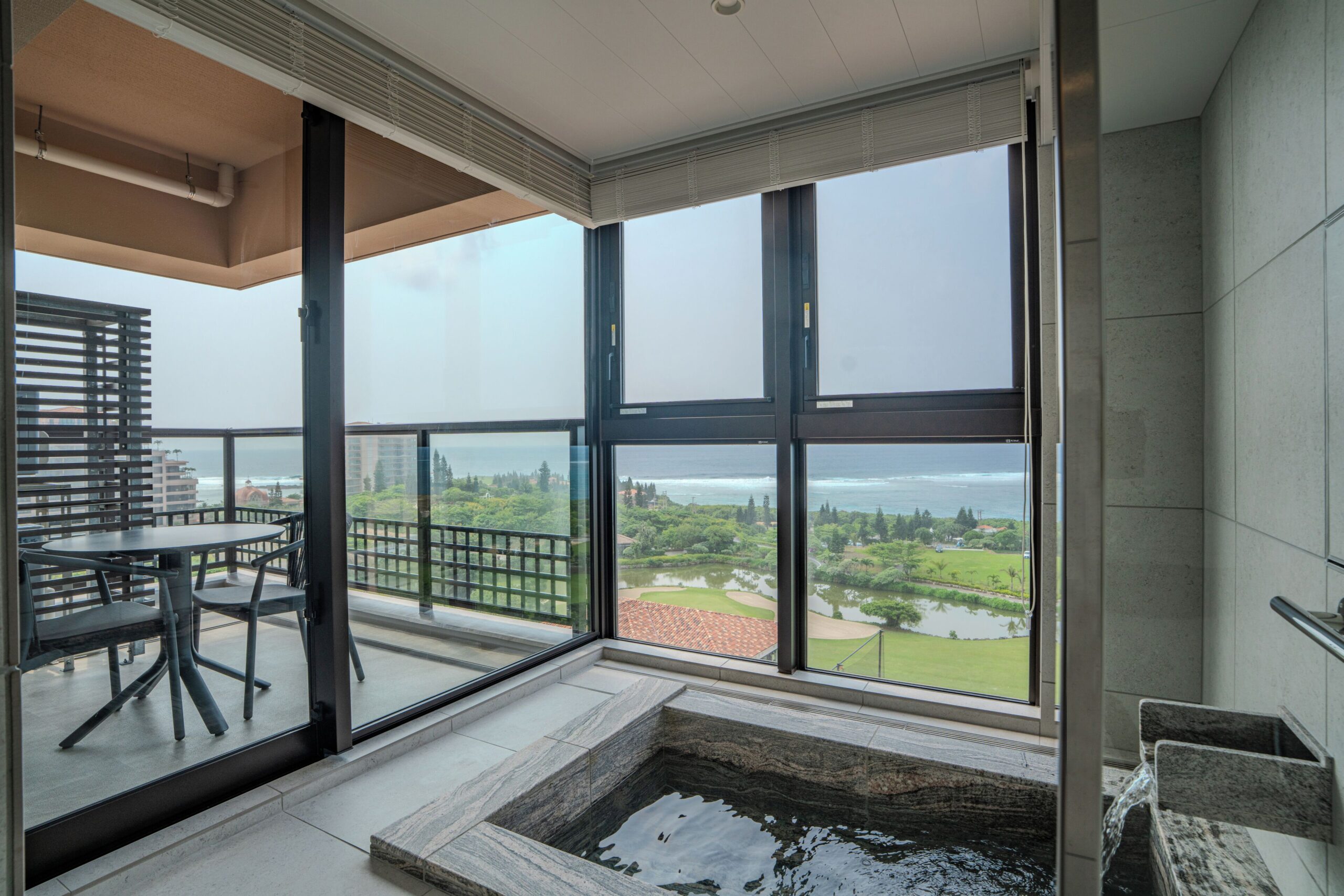 Stone bathtub beside corner windows in an Executive Ocean room at ALLAMANDA Splendid