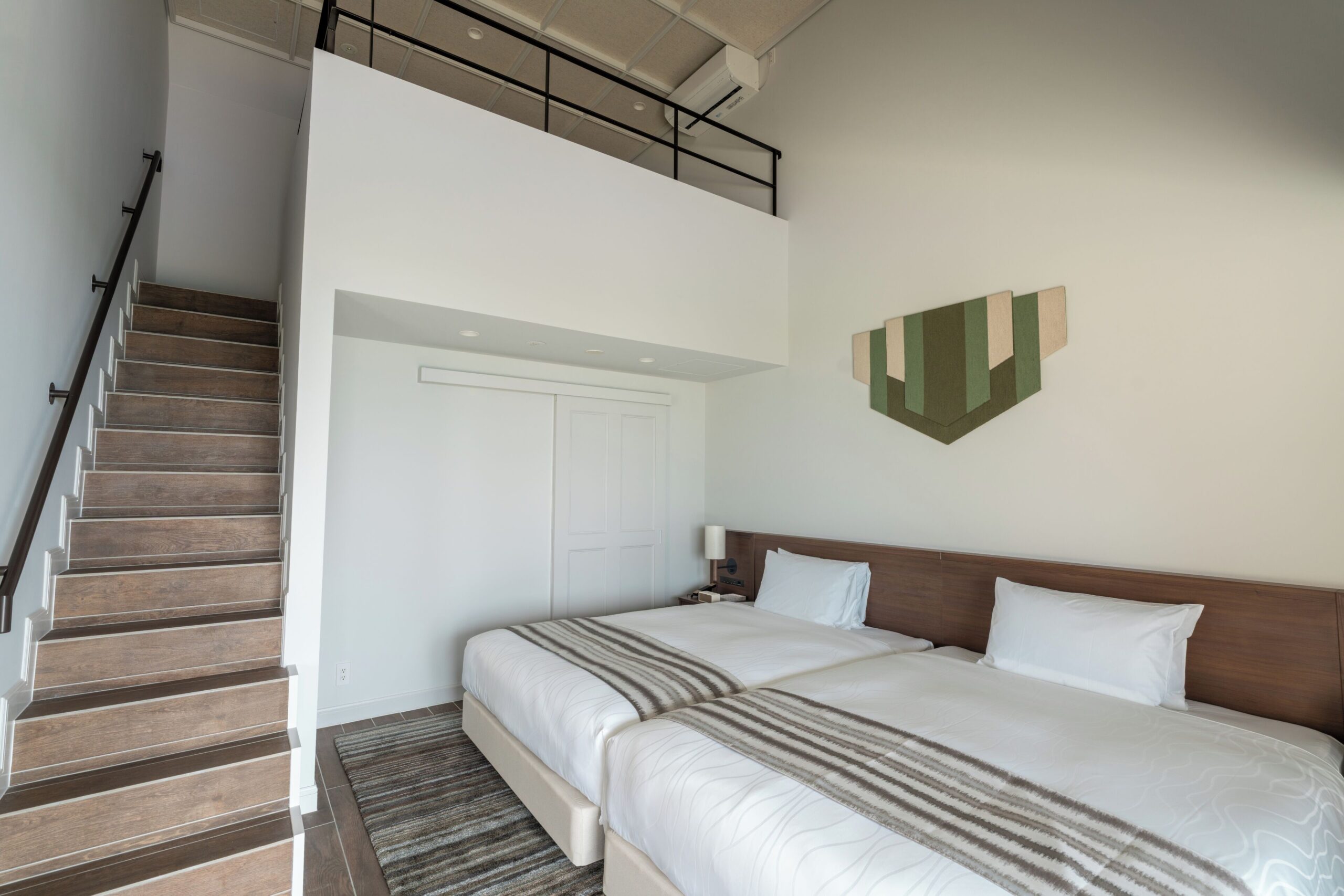 Bedroom and staircase to the loft in a Pool Villa Suite at ALLAMANDA Splendid