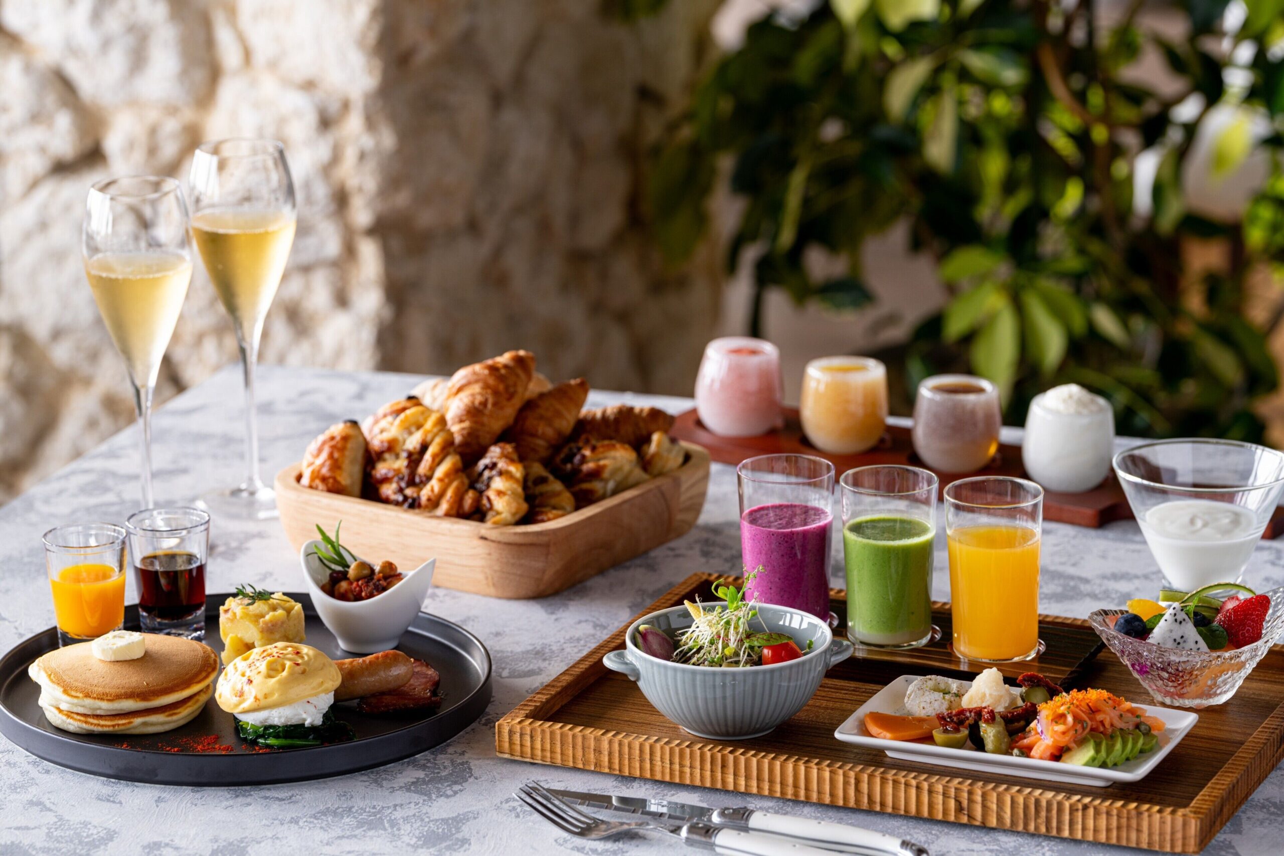 Breakfast dishes at With Blue, including pancakes, eggs, pastries, fruit and drinks