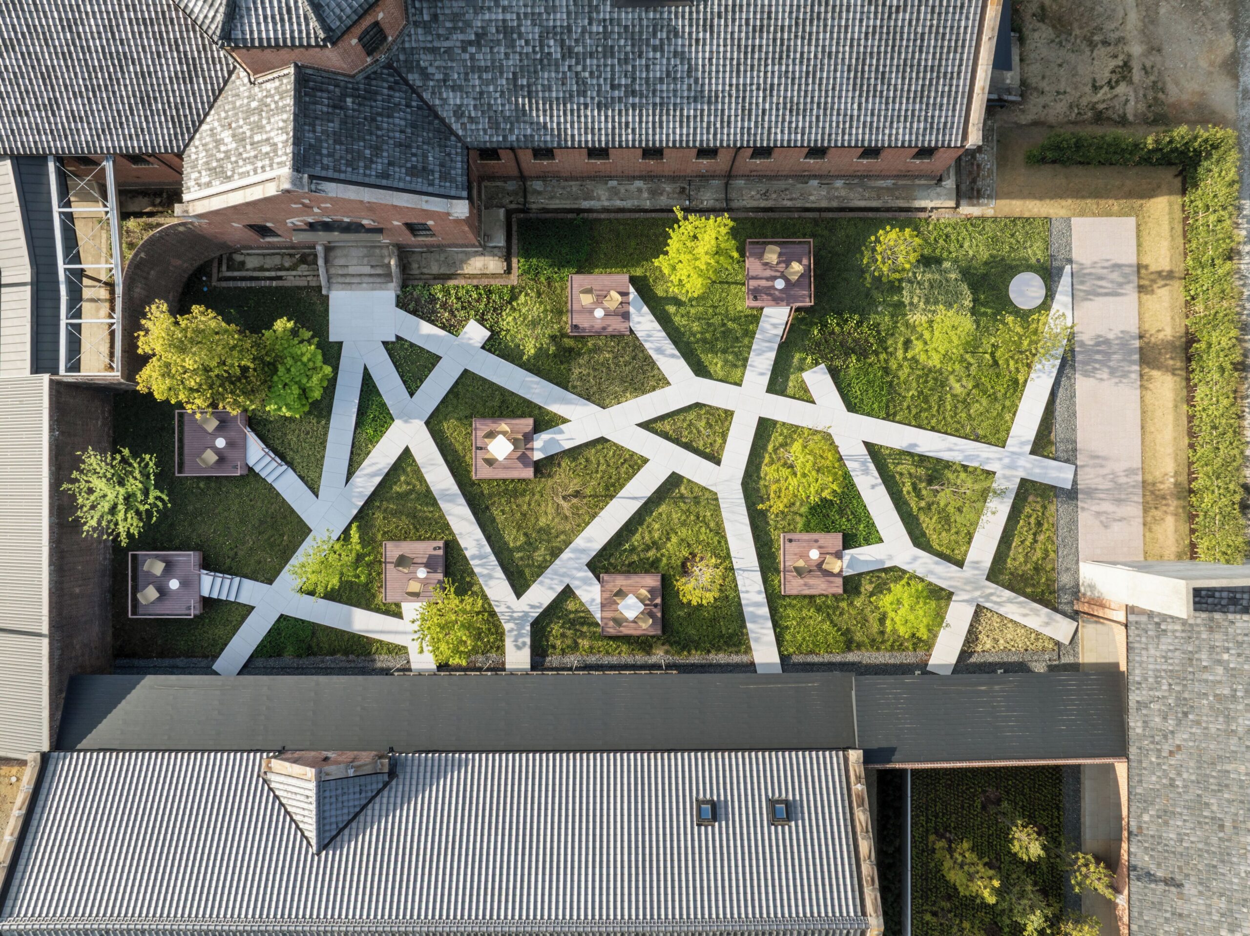 Aerial view of the geometric white paths and seating decks in the courtyard at HOSHINOYA Nara Prison