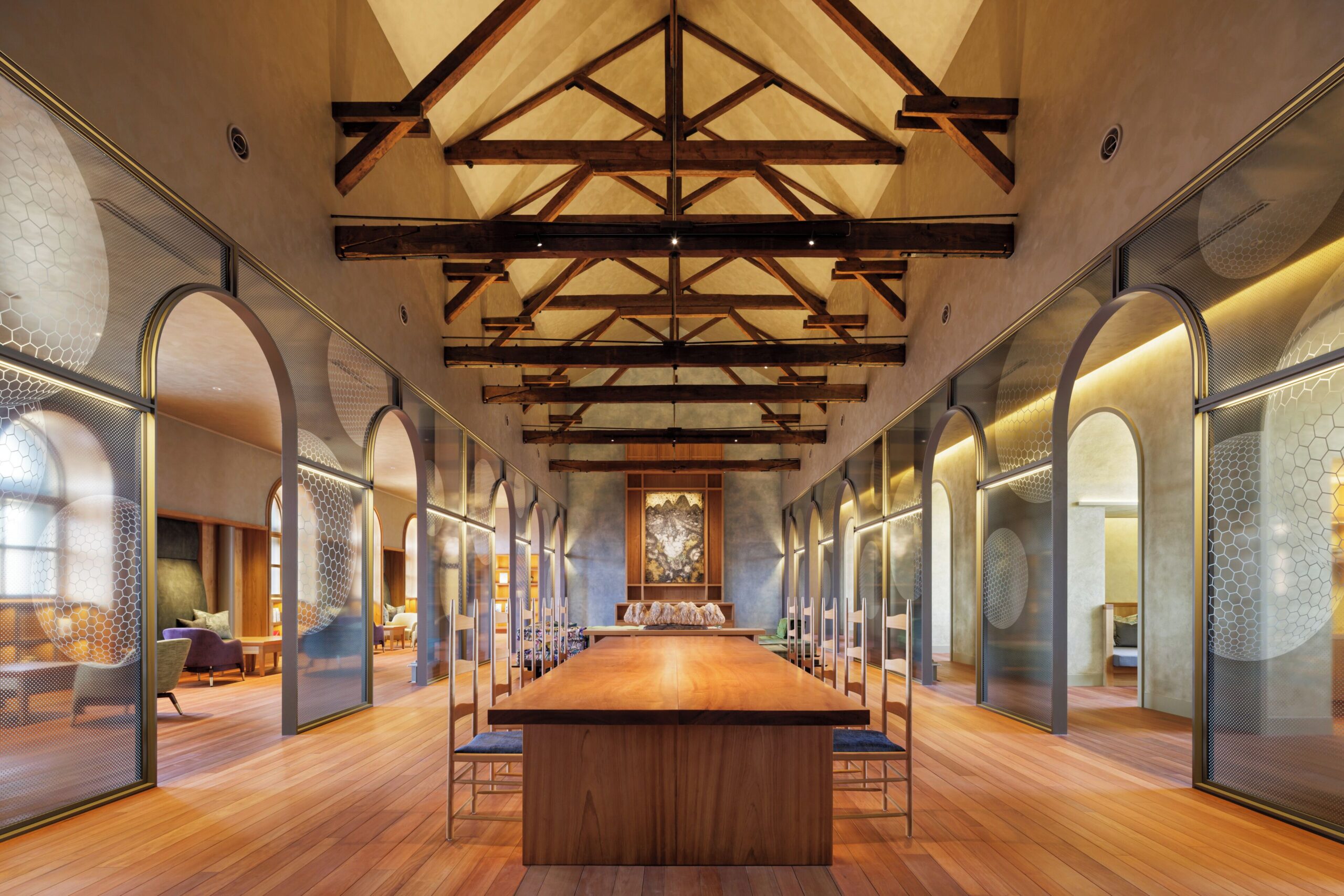 Main lounge at HOSHINOYA Nara Prison with exposed truss beams and arched partitions